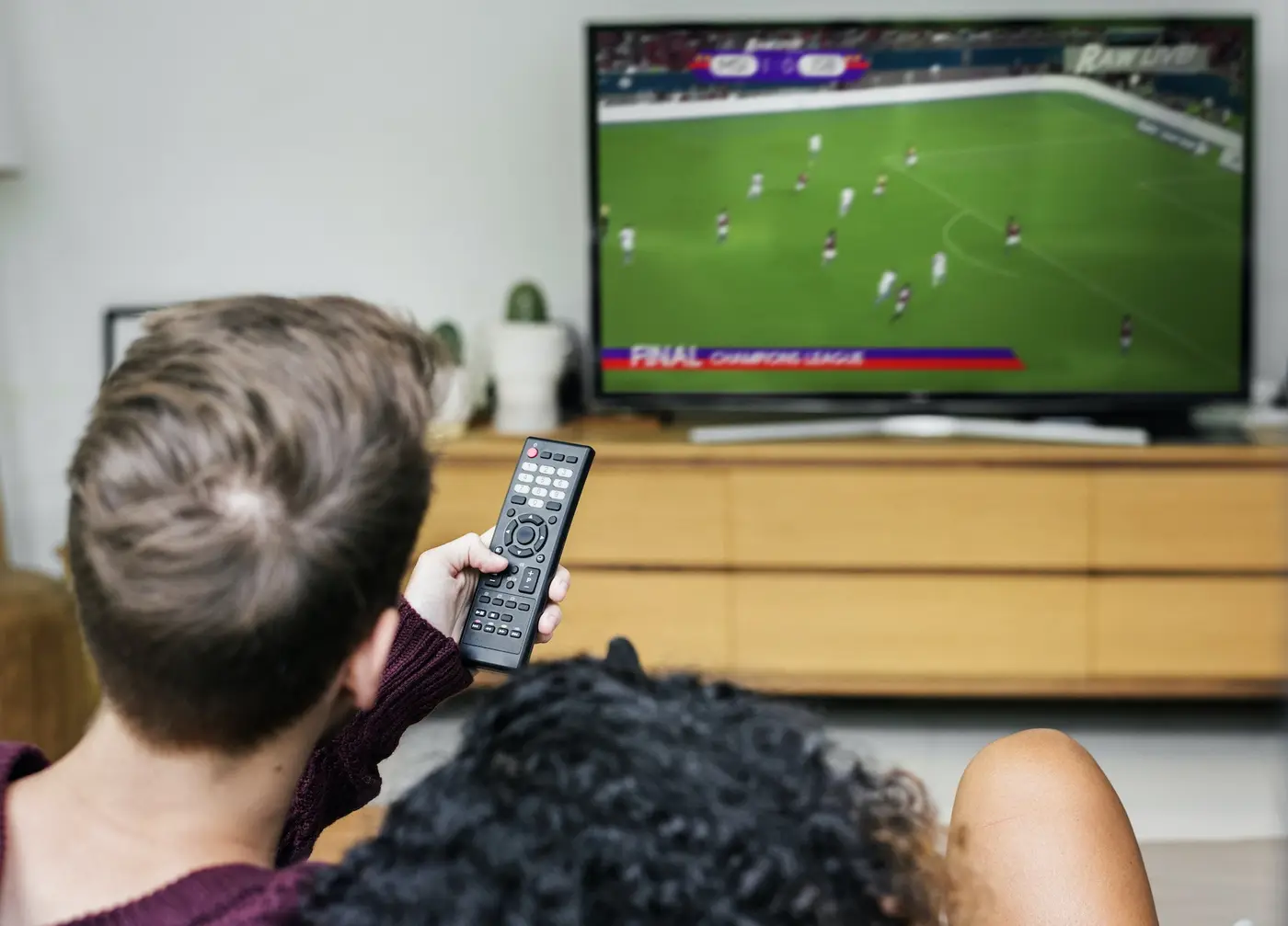 A couple watching a football match on TV with 1ClickTV